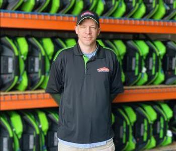 John in standing in front of a wall of green air movers