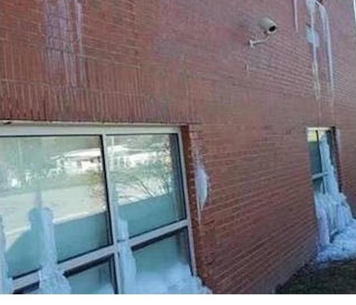 Freezing water coming out of a brick wall. 