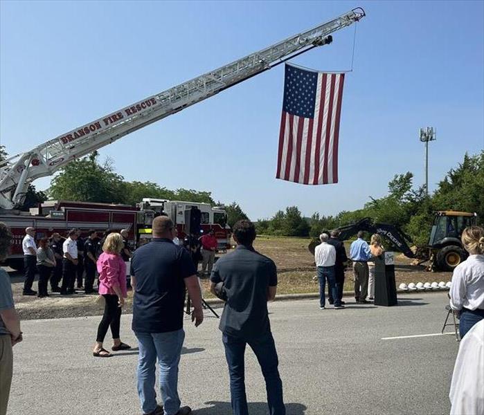 A firetruck raises a United States flag to celebrate a groundbreaking for Branson Fire Station #4
